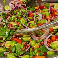 tomato-cucumber salad with onions, cilantro and pomegranate seeds
