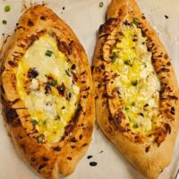 two deliciously cheesy khachapuri