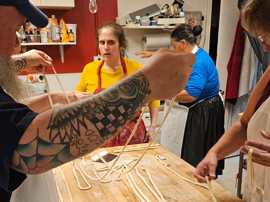 Guests stretching hand-pulled noodles during a Silk Road cooking class